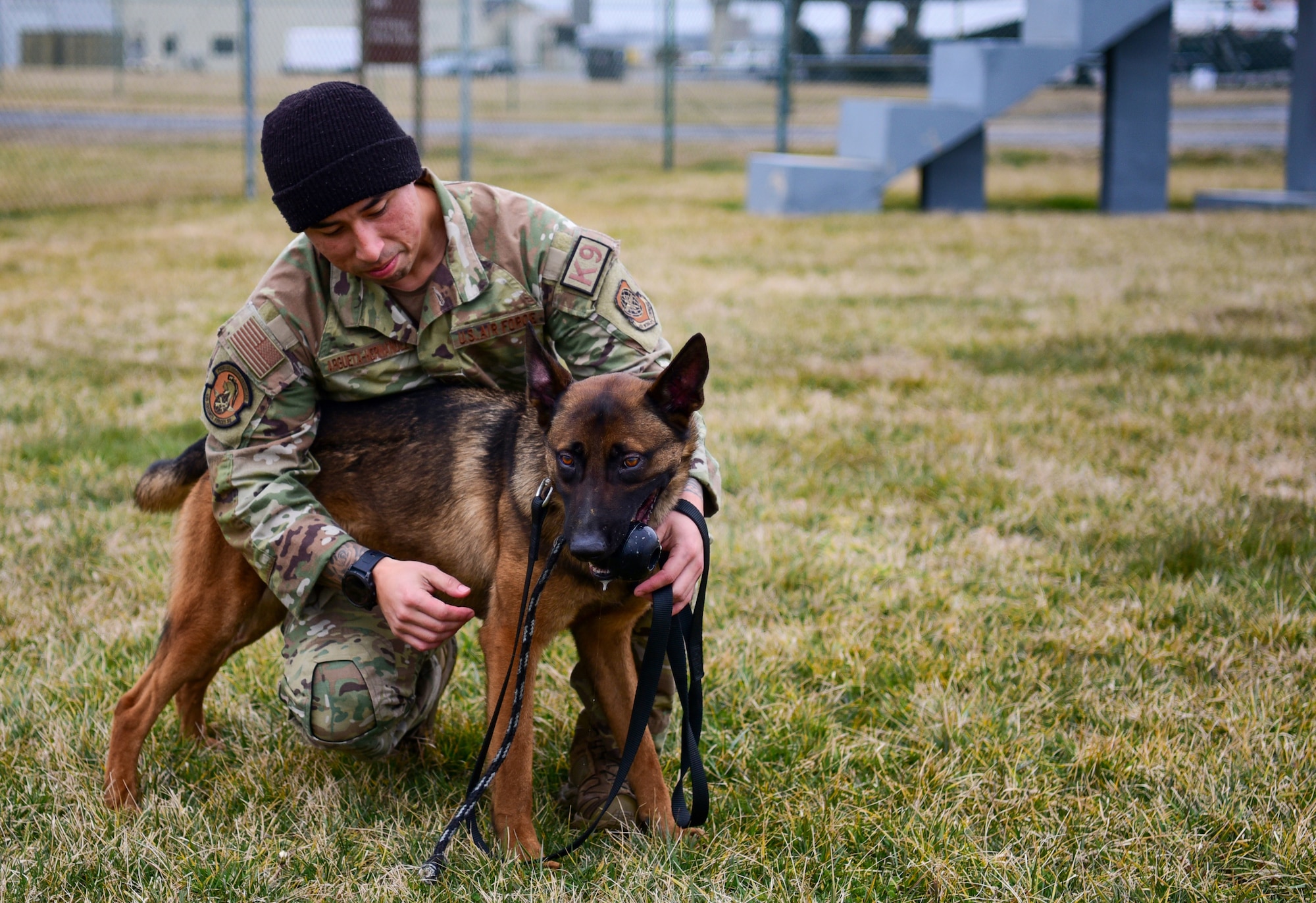 U.S. Air Force Staff Sgt. Edwin Argueta-Hernandez, Military Working Dog (MWD) Trainer, 436th Security Forces Squadron, and Tako, MWD Drug Detector assigned to the squadron, rest post-training at Dover Air Force Base, Feb. 23, 2024. Certified MWDs contribute to security measures against narcotics. Tako's training encompasses the detection of heroin, marijuana, and methamphetamine. (U.S. Air Force photo by Staff Sgt. Alexandra Minor)