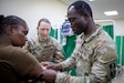 U.S. Army Reserve Spc. Israel Osagie, practical nursing specialist, and Sgt. Mary Denio, a combat medic, both from 425th Medical Detachment,176th Medical Brigade, 807th Medical Command, demonstrate the electrocardiogram machine with Kenyan Defence Forces Sgt. Emma Wangechi, registered nurse, in Nanyuki, Kenya on Feb, 29, 2024. Justified Accord 2024 (JA24) is U.S. Africa Command's largest exercise in East Africa, running from Feb. 26 - March 7. Led by U.S. Army Southern European Task Force, Africa (SETAF-AF), and hosted in Kenya, this year's exercise will incorporate personnel and units from 23 nations. This multinational exercise builds readiness for the U.S. joint force, prepares regional partners for UN and AU mandated missions, and increases multinational interoperability in support of humanitarian assistance, disaster response and crisis response. (U.S. Army Reserve photo by Spc. Ronald D. Bell)