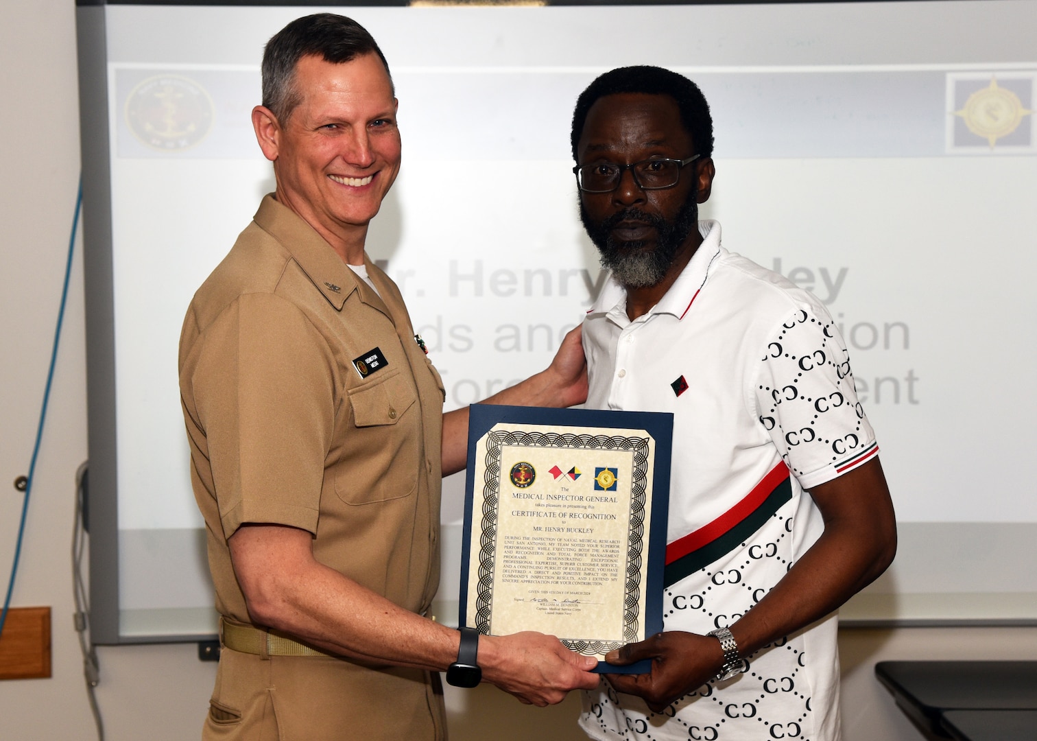 JOINT BASE SAN ANTONIO-FORT SAM HOUSTON – (March 6, 2024) – Henry V. Buckley, head, Administration Department, Naval Medical Research Unit (NAMRU) San Antonio, was recognized by Capt. William Deniston, medical inspector general (MEDIG), U.S. Navy’s Bureau of Medicine and Surgery (BUMED), for his exceptional professionalism and expertise for serving as the program manager for Awards and Recognition, and Total Force Management during the MEDIG outbrief held at the Battlefield Health and Trauma Research Institute. Approximately 12 inspectors conducted evaluations of 40 programs and collateral duties over three days at Naval Medical Research Unit (NAMRU) San Antonio to improve command performance and processes. NAMRU San Antonio’s mission is to conduct gap driven combat casualty care, craniofacial, and directed energy research to improve survival, operational readiness, and safety of DoD personnel engaged in routine and expeditionary operations. It is one of the leading research and development laboratories for the U.S. Navy under the DoD and is one of eight subordinate research commands in the global network of laboratories operating under the Naval Medical Research Command in Silver Spring, Md. (U.S. Navy photo by Burrell Parmer, NAMRU San Antonio Public Affairs/Released)