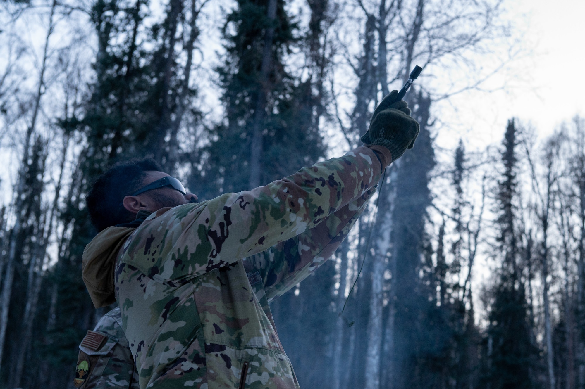U.S. Air Force Staff Sgt. Samuel Wells, Arctic survival student of class 24-09, element one, fires a signaling flare at the Arctic field training area on Eielson Air Force Base, Feb. 14, 2024.