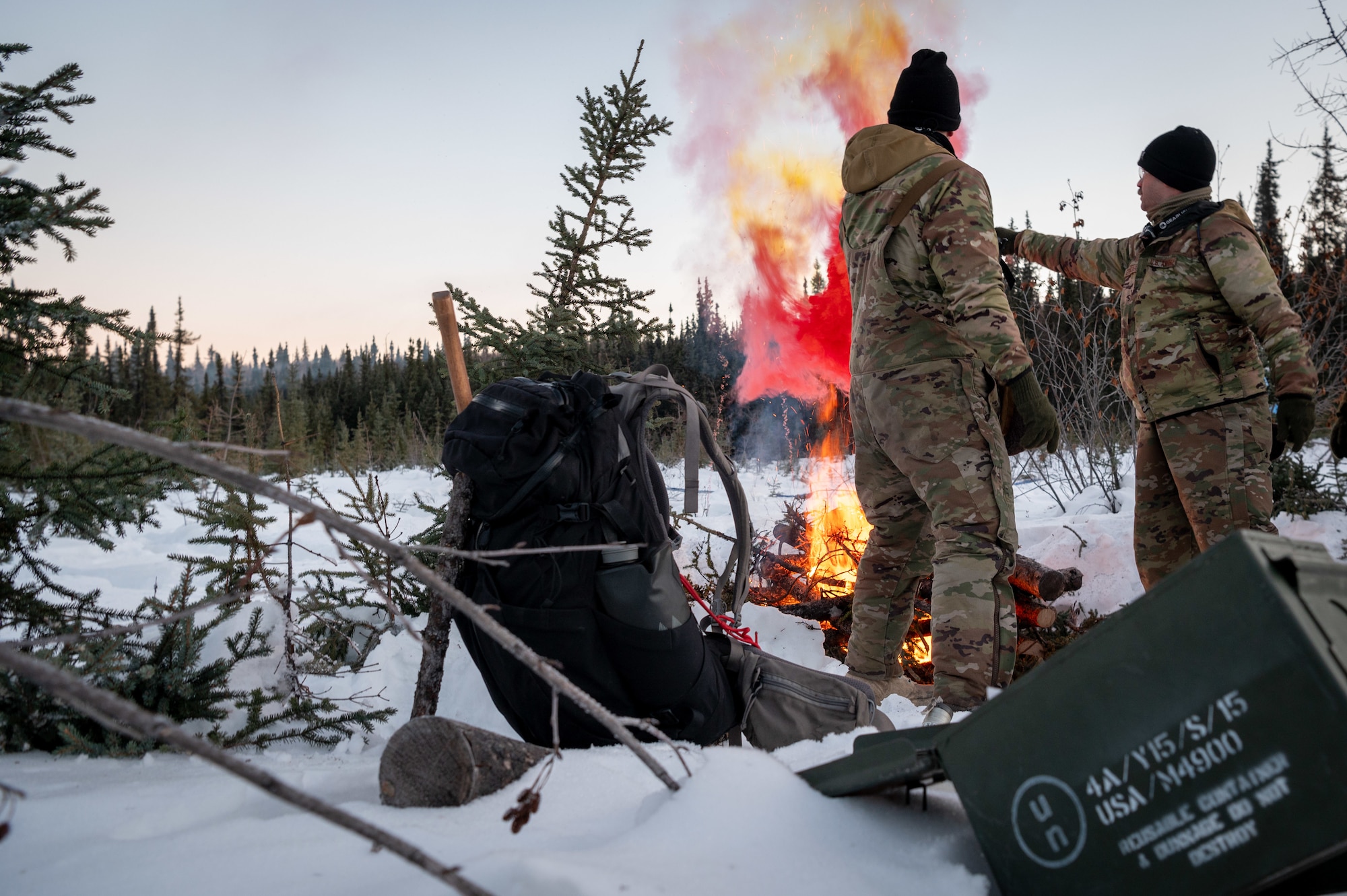U.S. Air Force master sergeants James Cain (left) and Justin Streitberger use MK-124 signaling flares at their ground-to-air signal (GTAS) area in the Arctic field training area on Eielson Air Force Base, Feb. 16, 2024.