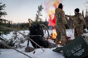 U.S. Air Force master sergeants James Cain (left) and Justin Streitberger use MK-124 signaling flares at their ground-to-air signal (GTAS) area in the Arctic field training area on Eielson Air Force Base, Feb. 16, 2024.