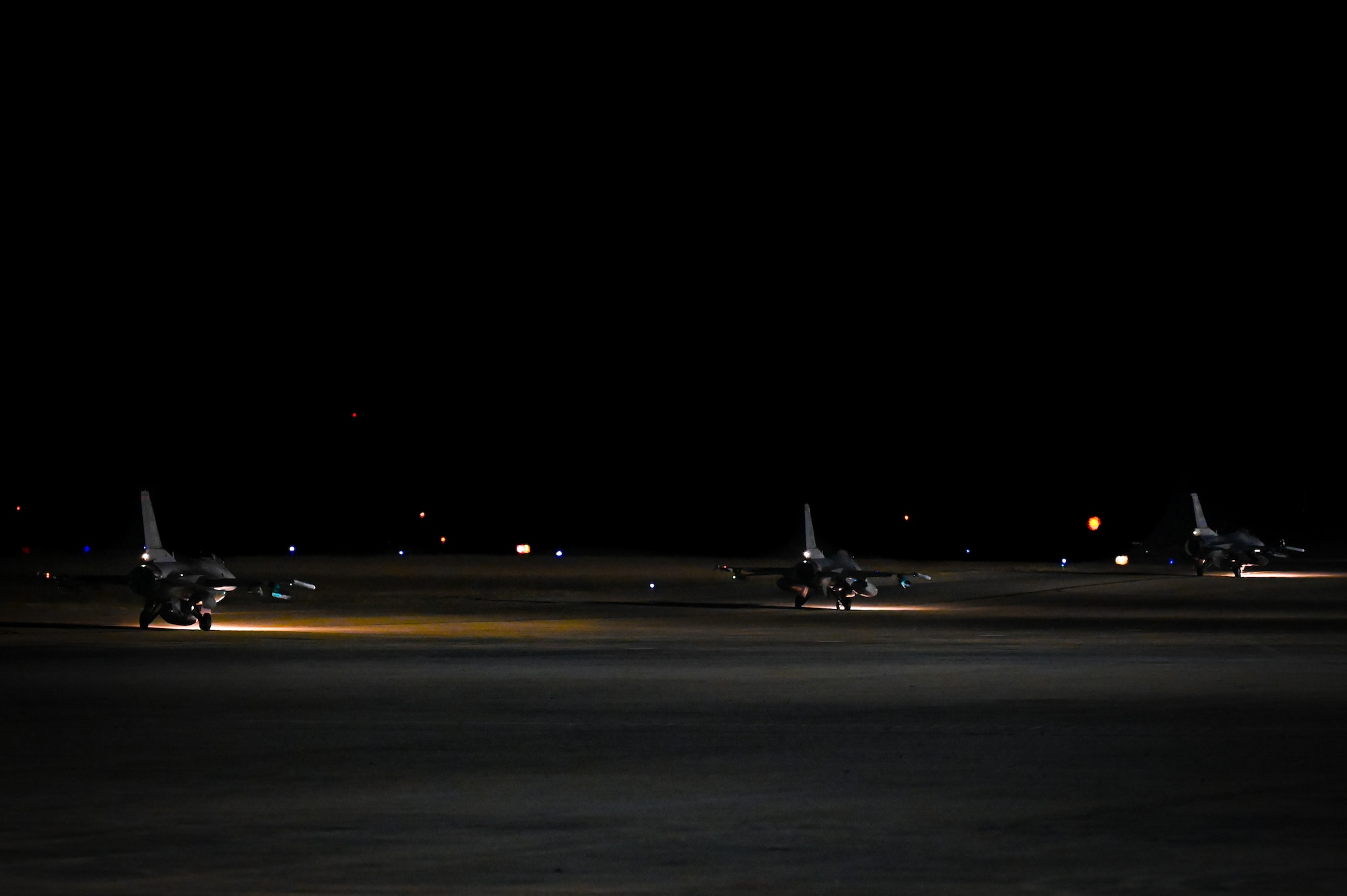 Three F-16C Reapers taxi on the flightline.