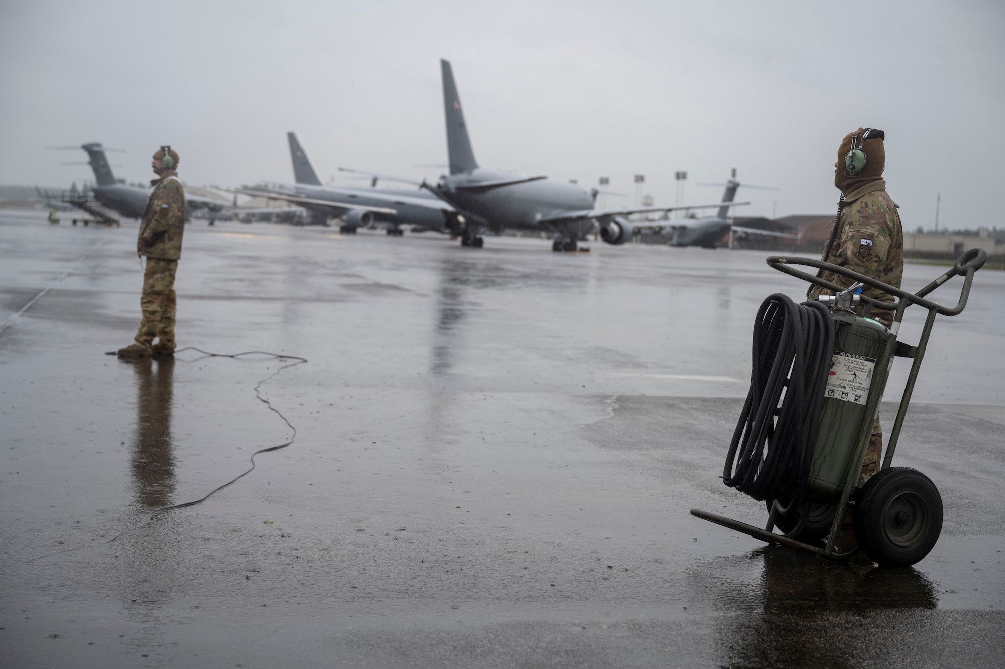 Tech Sgt. Patrick David, left, 722nd Aircraft Maintenance Squadron aircraft hydraulics craftsman, and Tech. Sgt. Rod Harris, 22nd AMXS crew chief, stand on the flightline during EXPLODEO Feb. 28, 2024, at Joint Base Lewis-McChord, Washington. EXPLODEO, a McConnell Air Force Base, Kansas, exercise, tested the 22nd and 931st Air Refueling Wings’ ability to rapidly deploy and employ into a theater. (U.S. Air Force photo by Airman 1st Class Gavin Hameed)