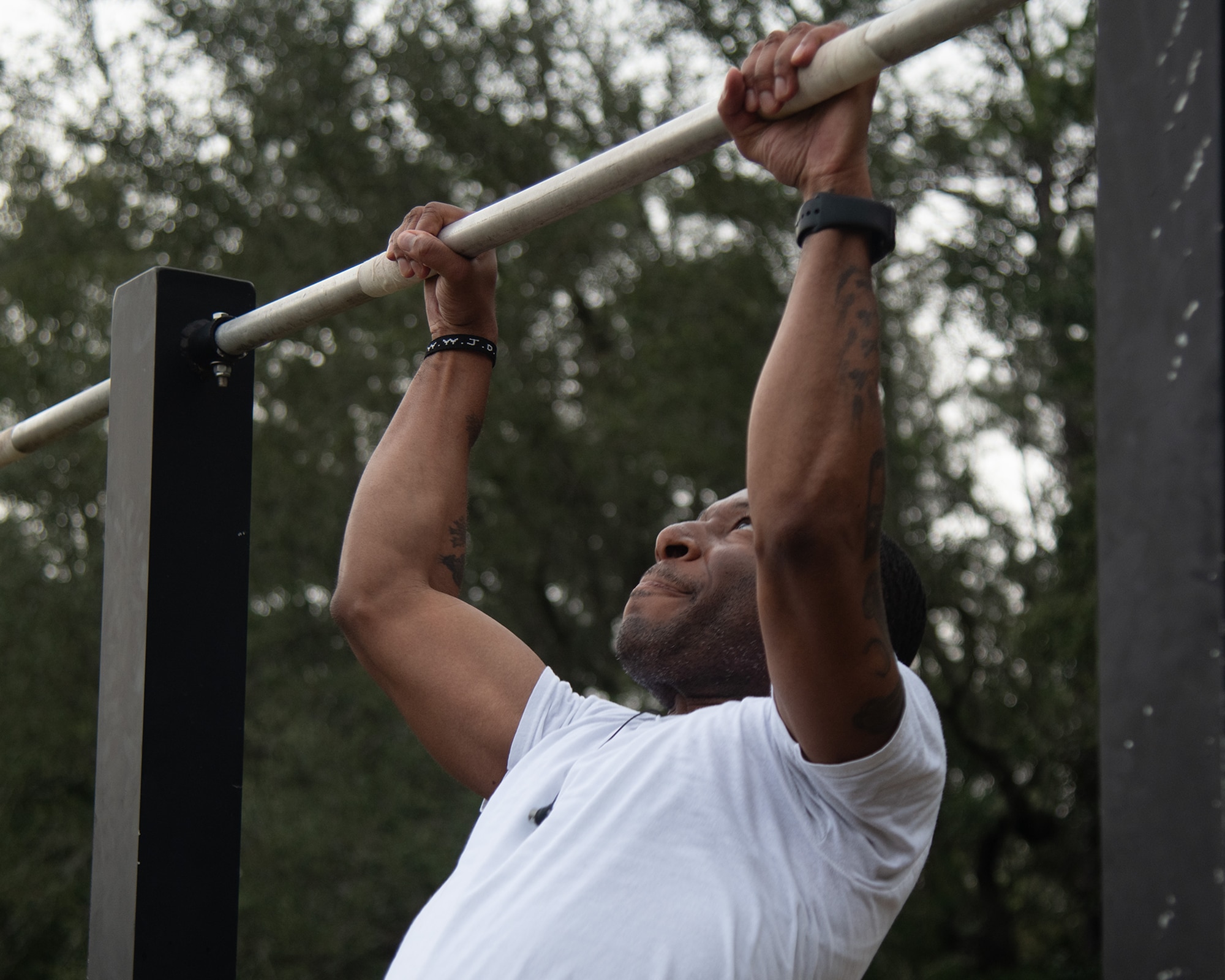 An Airman grips the pull-up bar during the Warrior Day Murph Challenge.