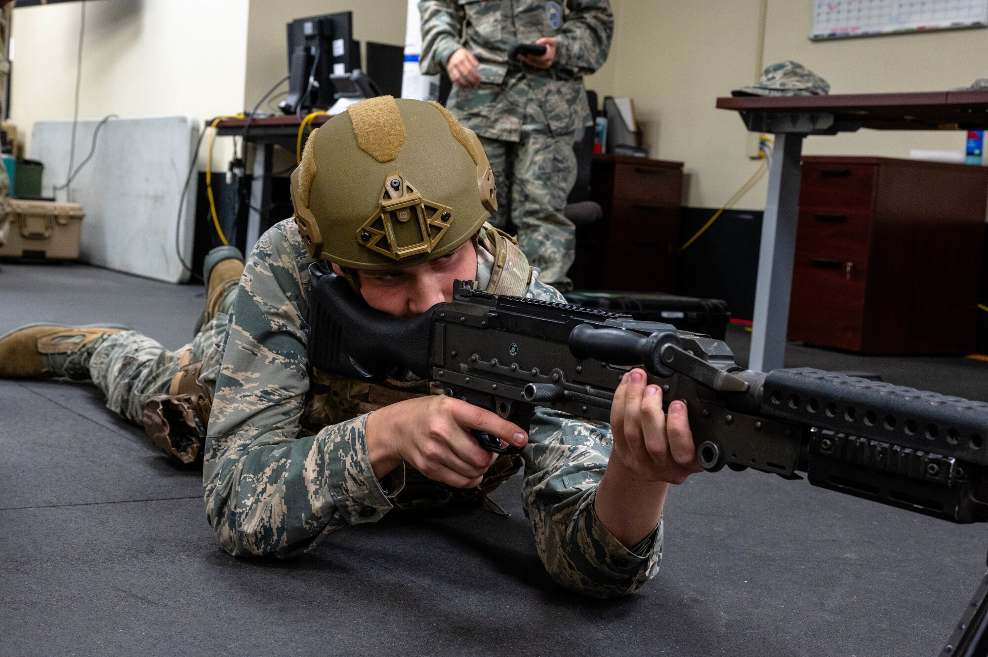 A Westwood High School Air Force Junior Reserve Officer Training Corps student interacts with a M240B medium machine gun employed by the 56th Security Forces Squadron during a base tour, Mar. 7, 2024, at Luke Air Force Base, Arizona.