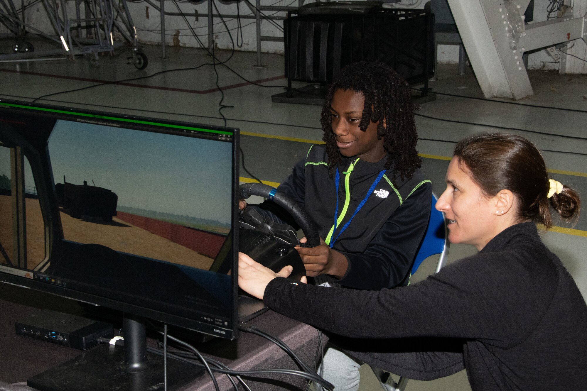 Rowland Jones-Coral, left, a Benjamin Benneker Middle School student, receives a demonstration about driving a military grade truck from Deirdre Cascardo, U.S. Army Aberdeen Test Center Public Affairs Officer., during the annual Aerospace Summit at Joint Base Andrews, Md., March 6, 2024.