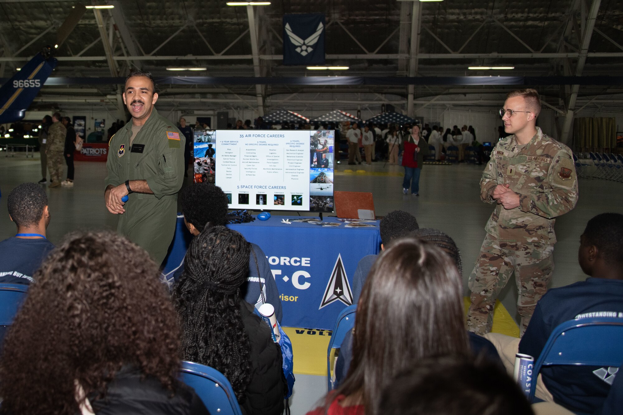 U.S. Air Force 2nd Lts. Brandon Garcia, left, 317th Recruiting Squadron Gold Bar Recruiter, and Ray Benson, Air Force Academy Admissions advisor, answer questions from students during a presentation on Air Force commissioning at the annual Aerospace Summit at Joint Base Andrews, Md., March 6, 2024.