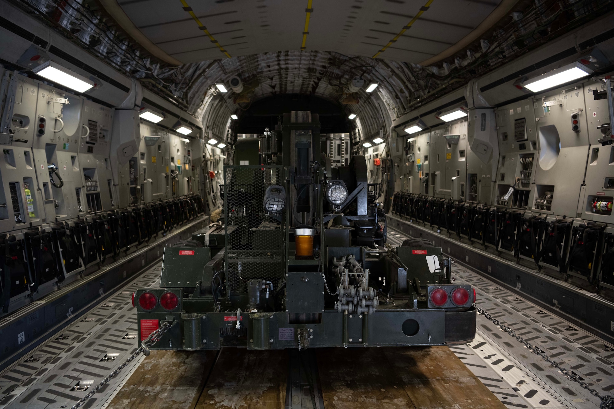 Machinery sits in the cargo hold of a large military aircraft