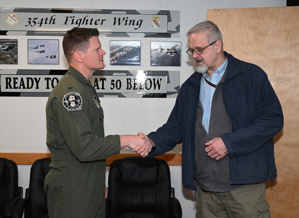 U.S. Air Force Col. Paul Townsend, 354th Fighter Wing commander, coins James Kurkowski, 354th Fighter Wing Special Security Office chief, at Eielson Air Force Base, Alaska, March 8, 2024.