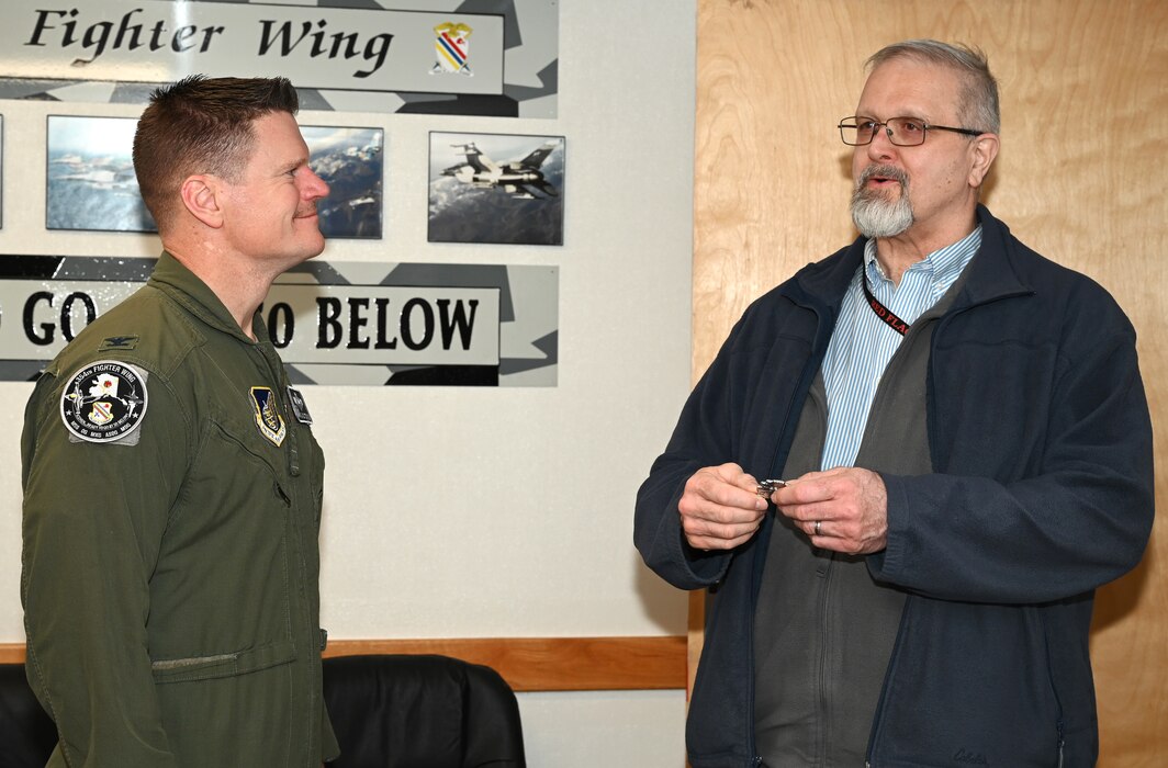 U.S. Air Force Col. Paul Townsend, 354th Fighter Wing commander, coins James Kurkowski, 354th Fighter Wing Special Security Office chief, at Eielson Air Force Base, Alaska, March 8, 2024.
