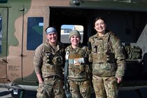 Crew stands outside helicopter