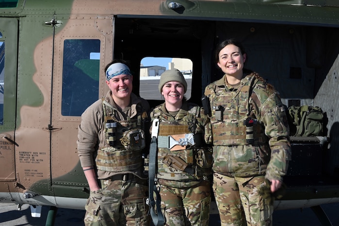 Crew stands outside helicopter