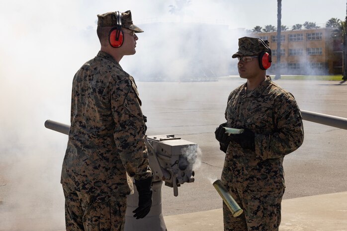 U.S. Marine Corps Cpl. Elliot Food-Johnson, a combat videographer with Headquarters Company, left, and Sgt. Jaime Aguilar, an operations training chief with Headquarters and Service Battalion, fire a ceremonial 40mm cannon to honor Lt. Gen. Brian Cavanaugh, Commanding General, Fleet Marine Force, Atlantic; Commander, Marine Forces Command; and Commander, Marine Forces Northern Command at Marine Corps Recruit Depot San Diego, California, Mar. 8, 2024. Cavanaugh visited the depot to participate in the graduation ceremony of Delta Company as the parade reviewing officer and was honored with a fifteen-gun salute. (U.S. Marine Corps photo by Cpl. Alexander O. Devereux)