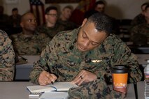 U.S. Marine Corps Sgt. Maj. Cyprian Johnson with Marine Aircraft Group 13, I Marine Expeditionary Force, takes notes during an ethics seminar course at Marine Corps Recruit Depot San Diego, California, Mar. 6, 2024. The ethics seminar is designed to provide train-the-trainer certifications on ethics from the Lejeune Learning Institution and Marine Corps University into entry level training to active-duty service members of MCRDSD. (U.S. Marine Corps photo by Lance Cpl. Janell B. Alvarez)
