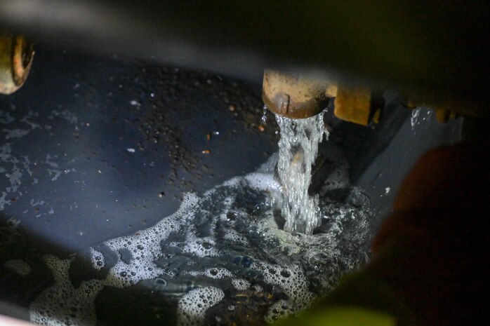A member in support of Joint Task Force-Red Hill (JTF-RH) drains the final gallons of accessible residual fuel into spill containment and removes it with a drainage line at the Red Hill Bulk Fuel Storage Facility (RHBFSF), Halawa, Hawaii, March. 6, 2024.
