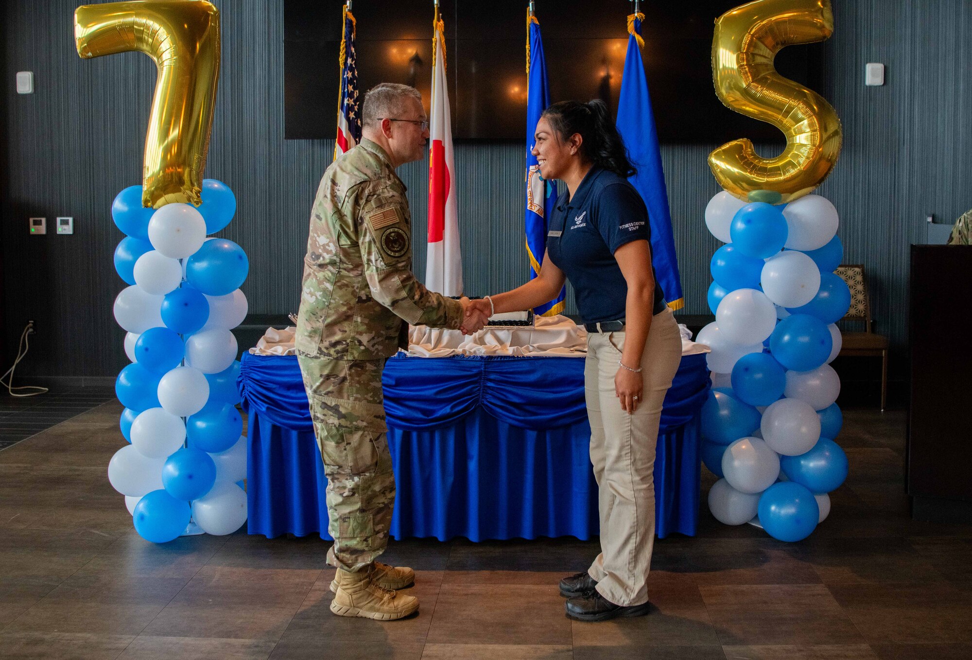 Two service members shake hands.