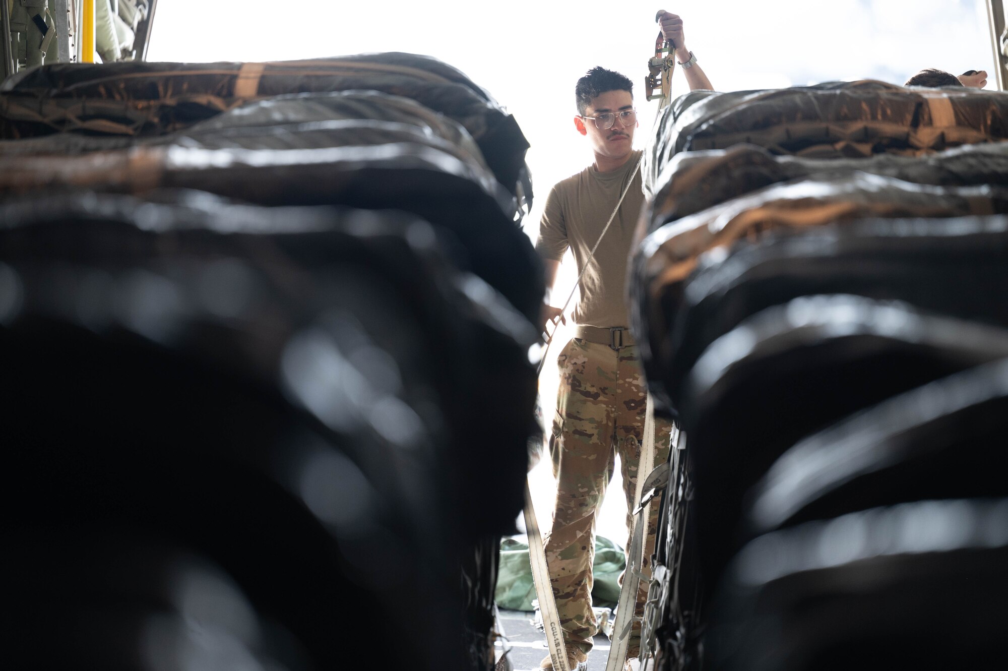 A loadmaster inspects humanitarian aid loaded aboard a C-130 at an undisclosed location.