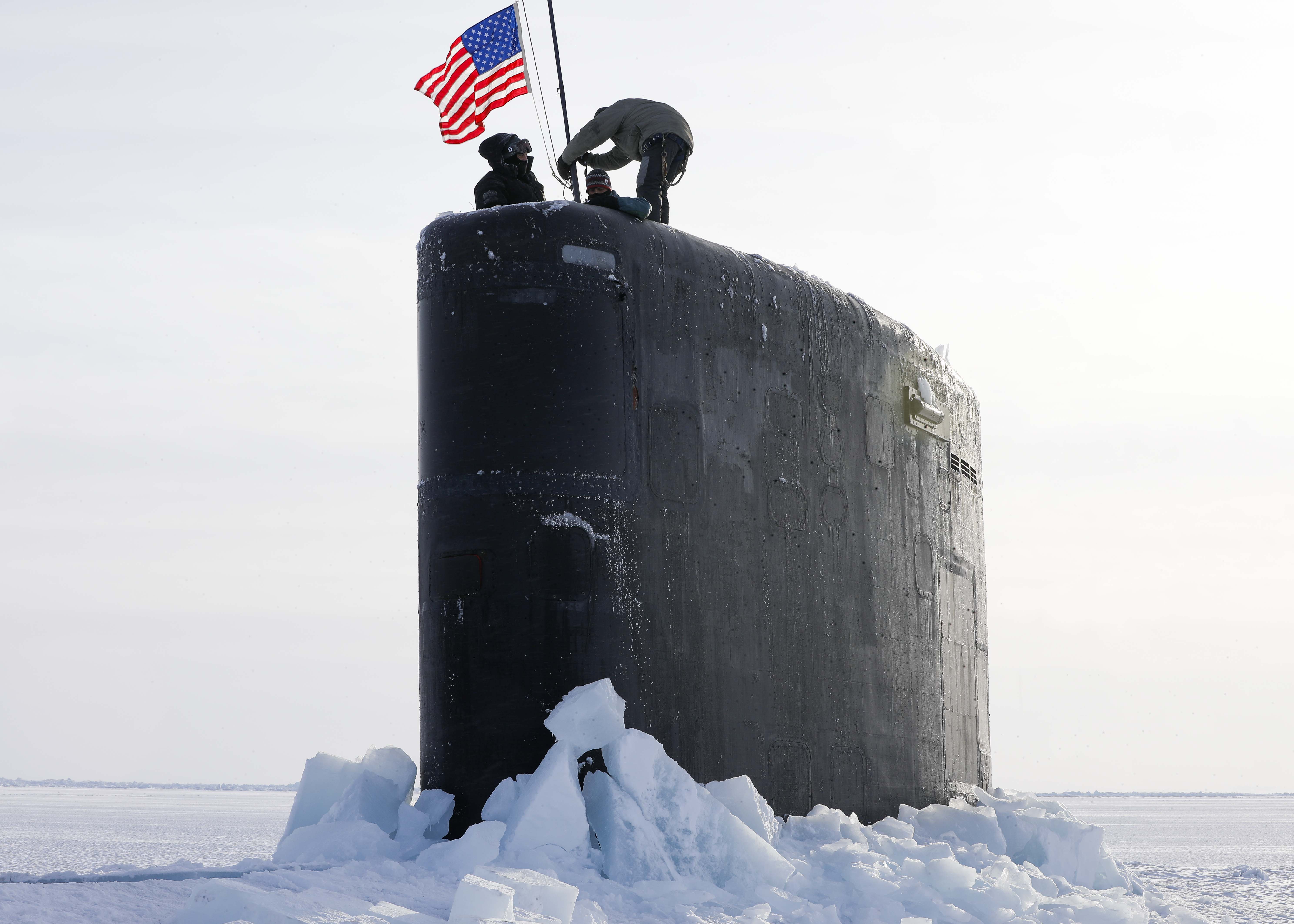 Sailors assigned to the Los Angeles-class attack submarine USS Hampton (SSN 767) raise the national ensign at Ice Camp Whale on the Arctic Ocean, during Ice Camp (ICE CAMP) 2024.