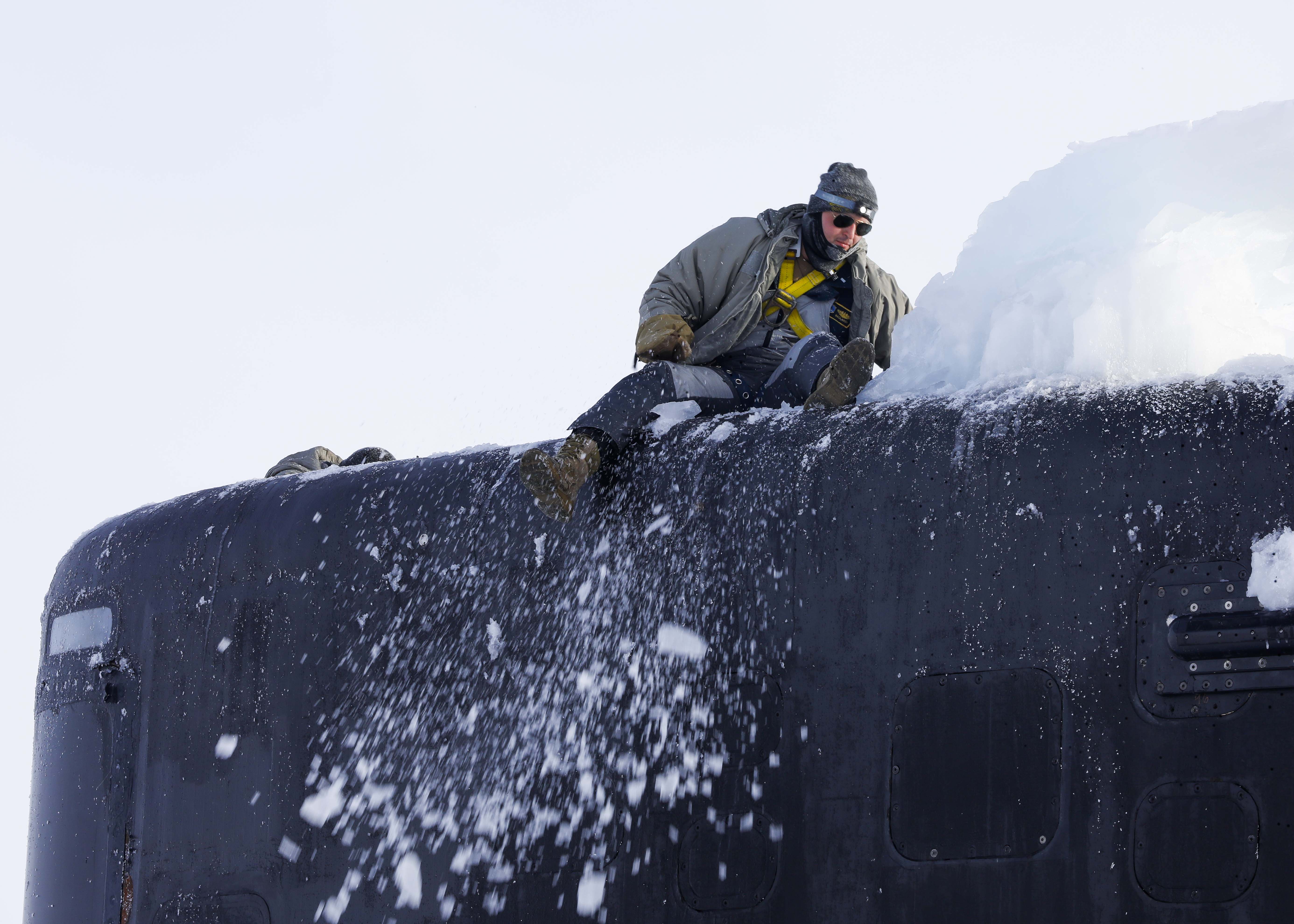 Sailors assigned to the Los Angeles-class attack submarine USS Hampton (SSN 767) remove ice from the submarine’s mast at Ice Camp Whale on the Arctic Ocean, during Ice Camp (ICE CAMP) 2024.