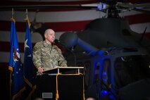 A man in military uniform stands behind a podium to speak into a microphone.