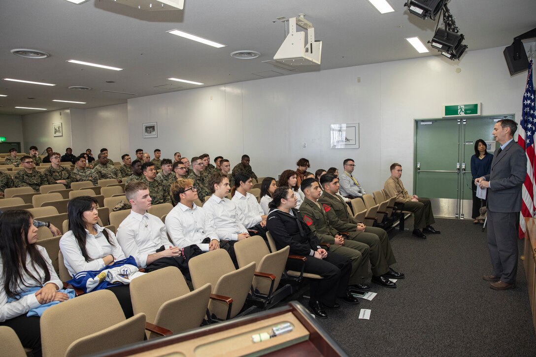 Samuel Bailey, a legal assistance attorney with Legal Services Support Team, gives a speech to U.S. service members, families, and students from Matthew C. Perry High School, during a naturalization ceremony at MCAS Iwakuni, Japan, Feb. 28, 2024. The naturalization ceremony was conducted to performed to welcome and celebrate the accomplishment of MCAS Iwakuni military members becoming citizens of the United States. The ceremony included service members from Mexico and Colombia. (U.S. Marine Corps Photos by Lance Cpl. Dahkareo Pritchett)