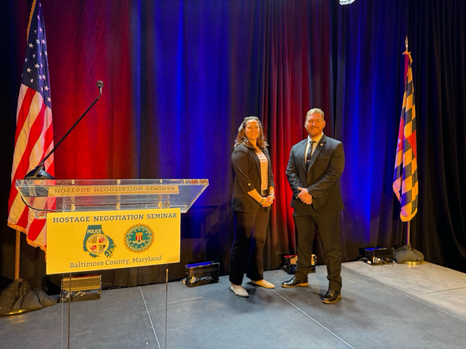 Two Special Agents stand on the stage at the 43rd Annual Hostage Negotiation Seminar in Baltimore