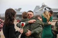 A piolot, assigned to the “Golden Warriors” of Strike Fighter Squadron (VFA) 87, reunites with his family.