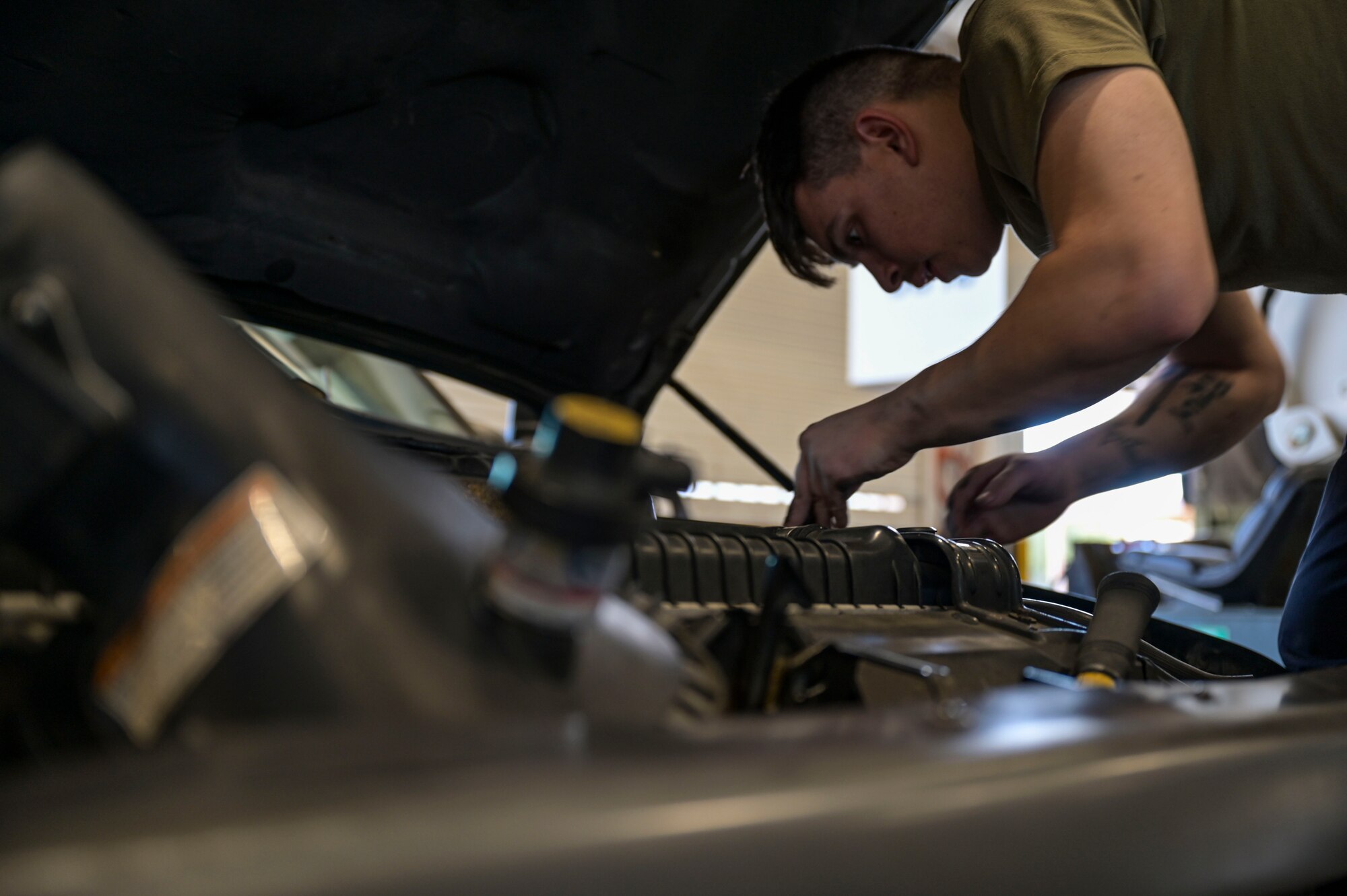 U.S. Air Force Airman 1st Class Jake Mendoza, a 1st Special Operations Logistics Readiness Squadron vehicle maintenance journeyman, inspects a vehicle's engine.