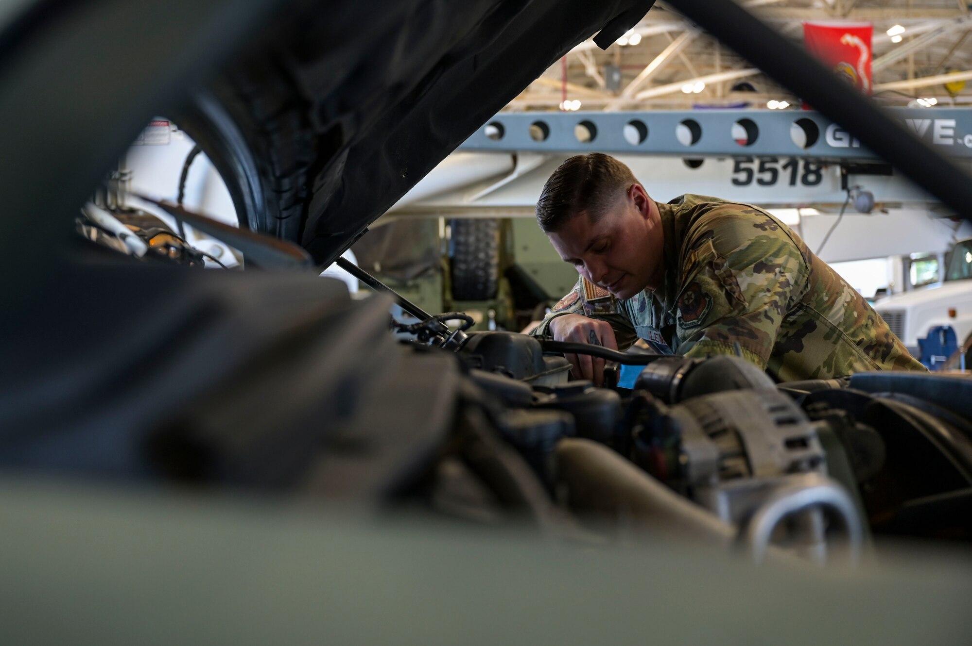U.S. Air Force Tech Sgt. Corey Lewis, 1st Special Operations Logistics Readiness Squadron Non-Commissioned Officer in charge of material control, inspects a vehicle’s engine.