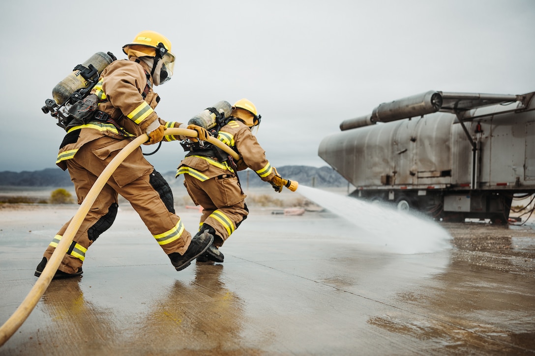 U.S. Marine Corps Cpl. Jesus Ramos, a San Antonio, Texas native, right, and Lance Cpl. Stephen Beaver, a Sellersburg, Indiana native, both expeditionary firefighting and rescue specialists with Marine Wing Support Squadron 271, Marine Aircraft Group 14, 2nd Marine Aircraft Wing, sweep the ground to simulate a spilled oil fire while in support of a Marine Air-Ground Task Force Warfighting Exercise during Service Level Training Exercise 2-24 at Camp Wilson, Marine Corps Air-Ground Combat Center, Twentynine Palms, California Feb. 20, 2024.  MWX is the culminating event for SLTE 2-24 that improves U.S. and allied service members’ operational capabilities and lethality as a MAGTF. (U.S. Marine Corps photo by Lance Cpl. Richard PerezGarcia)