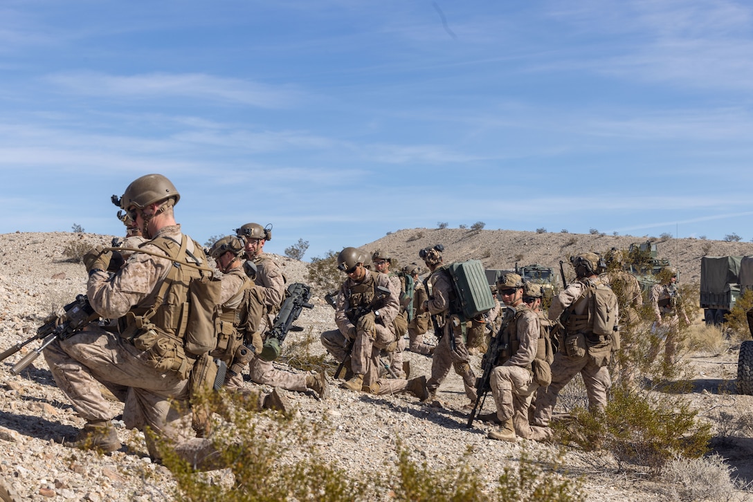 U.S. Marines with 2nd Battalion, 4th Marine Regiment, 1st Marine Division, prepare to move for a ground assault during a Marine Air-Ground Task Force Distributed Maneuver Exercise as part of Service Level Training Exercise 2-24 around Gays Pass training area, Marine Corps Air-Ground Combat Center, Twentynine Palms, California, Feb. 14, 2024. MDMX prepares Marines for future conflicts by conducting offensive and defensive live-fire and maneuver training scenarios within an austere training environment. (U.S. Marine Corps photo by Lance Cpl. Anna Higman)