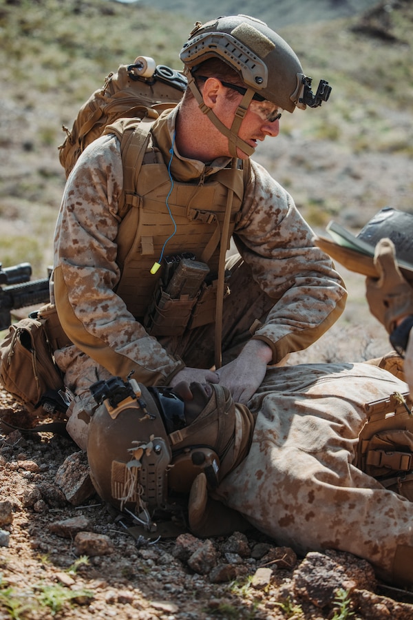 U.S. Navy Hospitalman 3rd class Devin Hutcheson, a Rockport, Maine native, with Charlie Company, 1st Battalion, 4th Marine Regiment, 1st Marine Division, provides aid to a simulated casualty during a Marine Air-Ground Task Force Distributed Maneuver Exercise as part of Service Level Training Exercise 2-24 at Marine Corps Air-Ground Combat Center, Twentynine Palms, California, Feb. 15, 2024. MDMX is designed to test the MAGTF’s operational capabilities in austere, multi-domain, offensive and defensive operations against adversaries at a regimental level. (U.S. Marine Corps photo by Lance Cpl. Justin J. Marty)