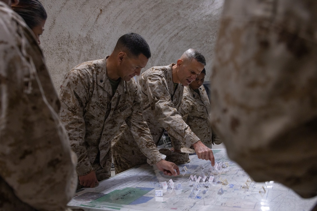 U.S. Marine Corps Brig. Gen. Andrew Niebel, a Bethesda, Maryland native, commanding general of 1st Marine Logistics Group, center right, and Lt. Col. Robert Hillery, a San Diego, California native, commanding officer of Combat Logistics Battalion 11, 11th Marine Expeditionary Unit, 1st MLG, are briefed on exercise movements during a Marine Air-Ground Task Force Warfighting Exercise as part of Service-Level Training Exercise 2-24 at Camp Wilson, Marine Corps Air-Ground Combat Center, Twentynine Palms, California, Feb. 22, 2024. Niebel visited The Combat Center to observe SLTE 2-24, a realistic, training environment that produces combat-ready forces capable of operating as an integrated MAGTF. (U.S. Marine Corps photo by Lance Cpl. Enge You)