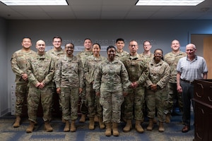 Members of the Individual Protective Equipment Section of the Enterprise Mobility Equipment and Clothing Flight Management Flight line up in the 435th SCOS office