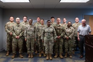 Members of the Individual Protective Equipment Section of the Enterprise Mobility Equipment and Clothing Flight Management Flight line up in the 435th SCOS office