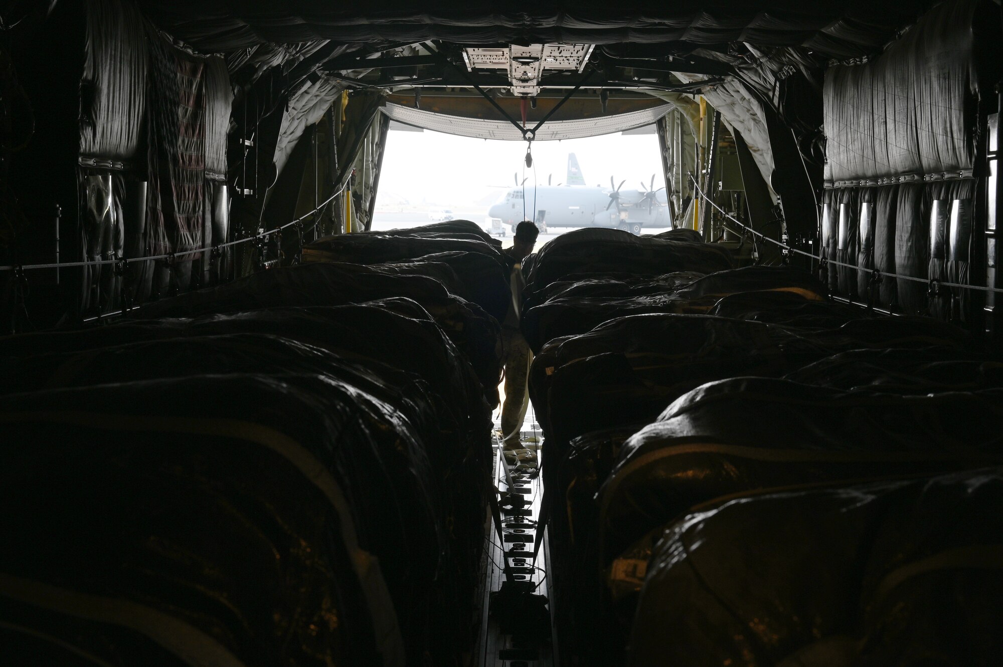 A loadmaster inspects pallets of packaged food and water supplies for humanitarian aid airdrops in multiple locations outside of population centers throughout Gaza.