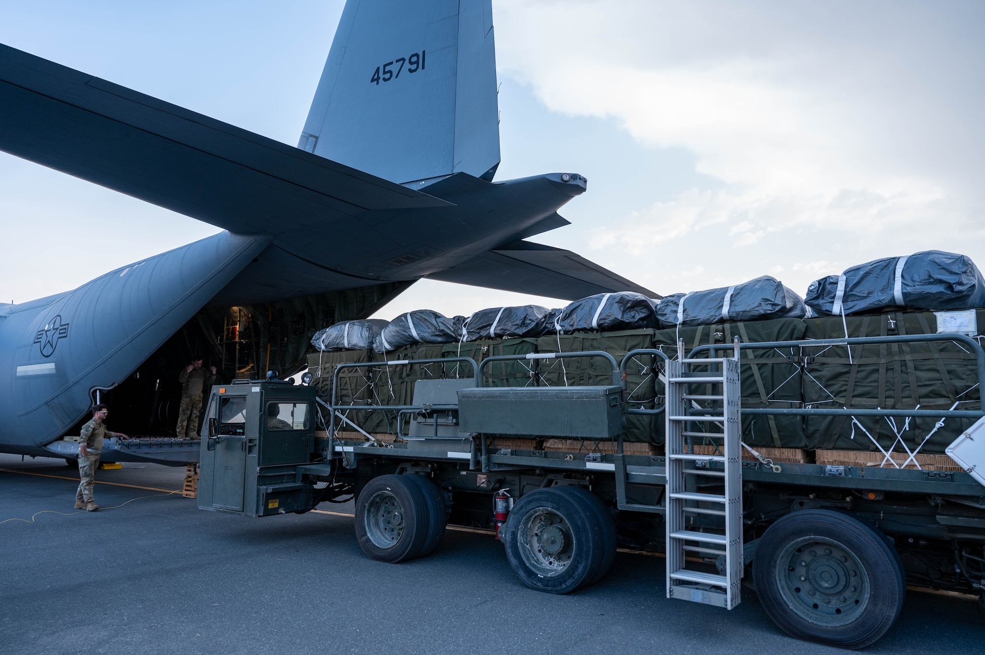 Loadmasters usher in pallets of food and water destined for airdrop over Gaza.