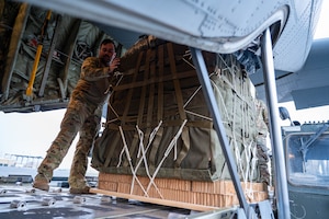 A loadmaster loads a pallet of humanitarian aid destined for Gaza aboard a HC-130J at an undisclosed location.