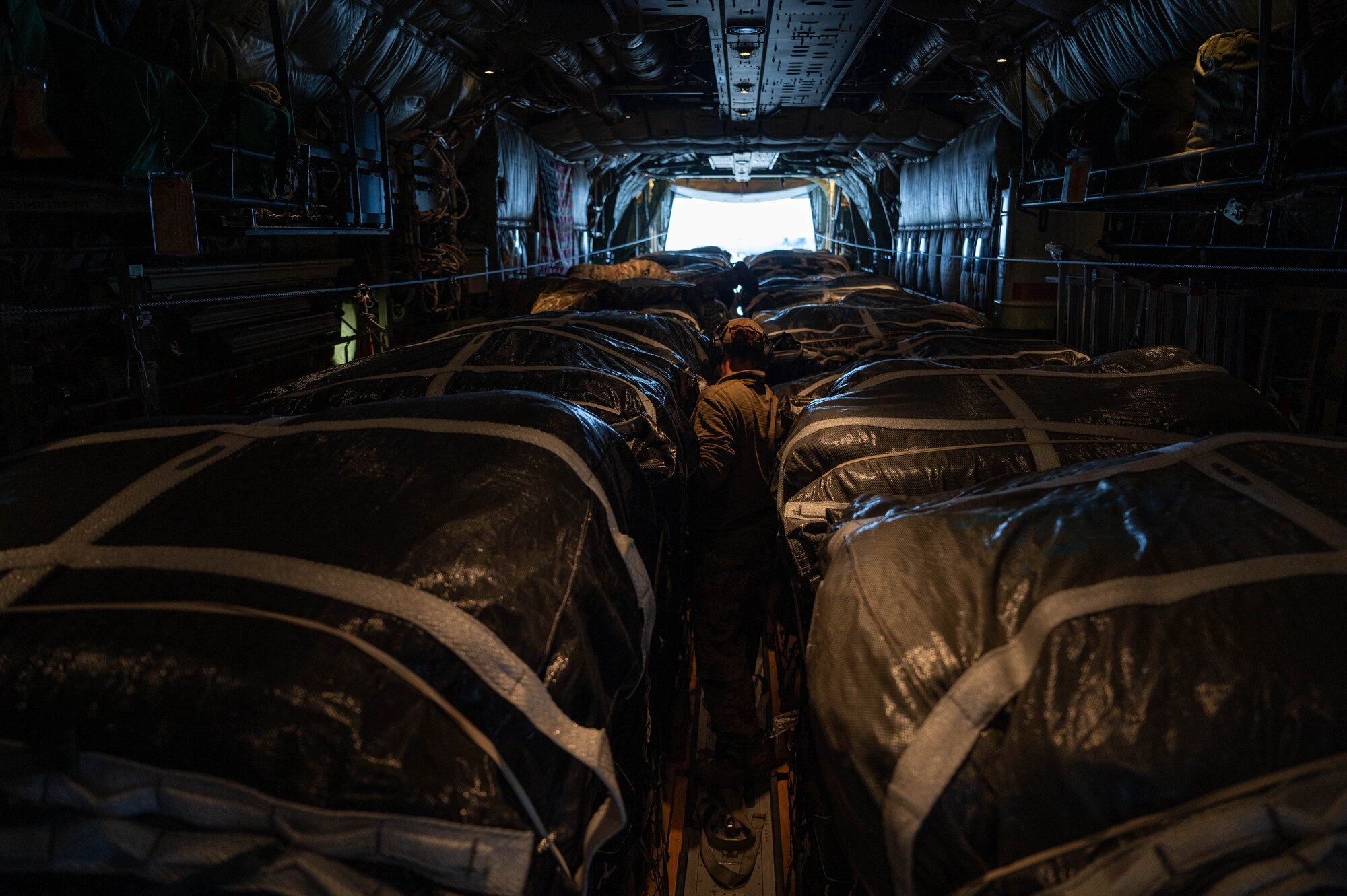 A loadmaster inspects humanitarian aid, bound for airdrop over Gaza.