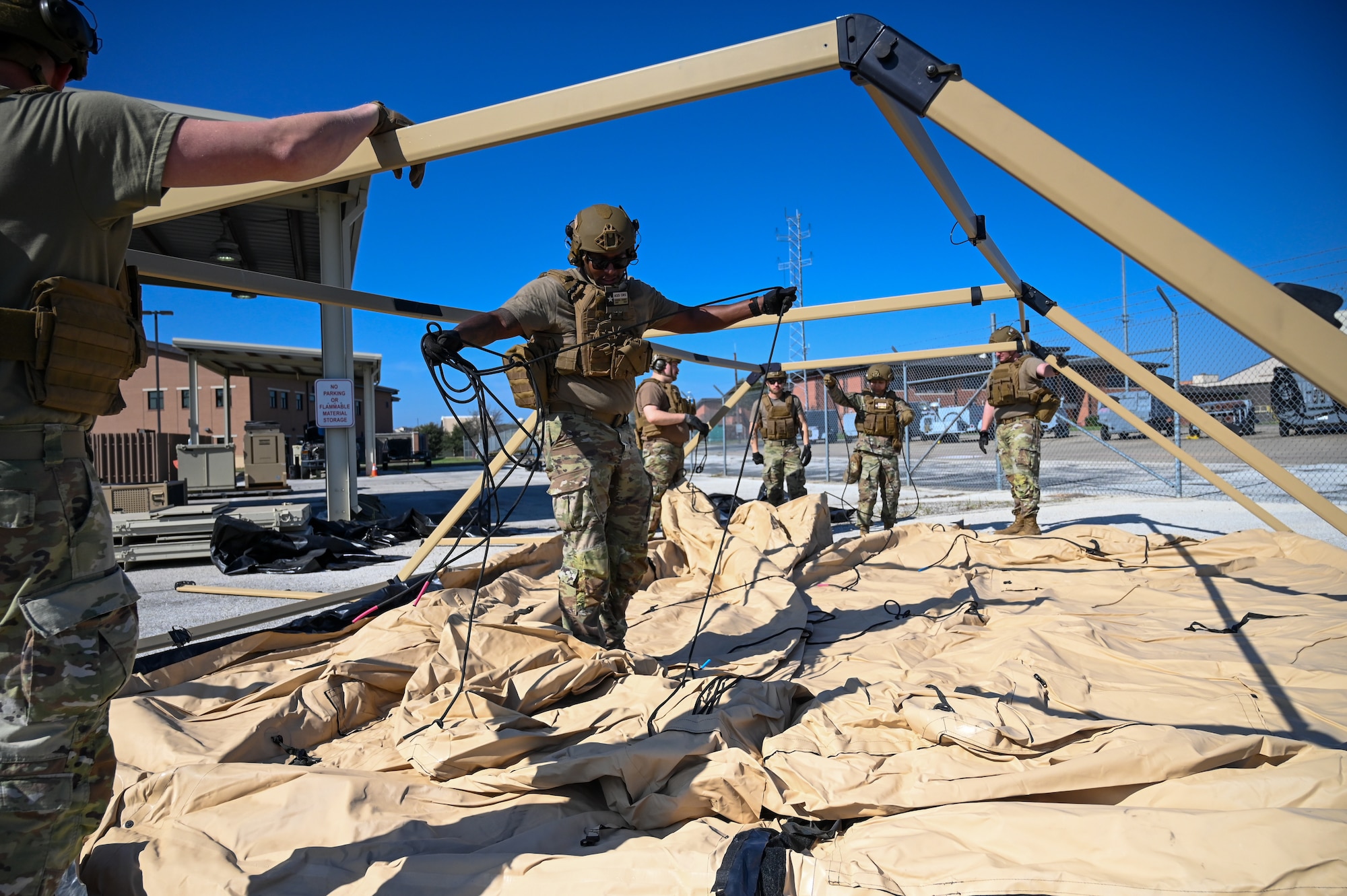 Staff Sgt. Joshua Chaney, center, 433rd Contingency Response Flight radio frequency non-commissioned officer, prepares tent ropes at a training campsite during a training event at Joint Base San Antonio-Lackland, Texas on Mar. 2, 2024.