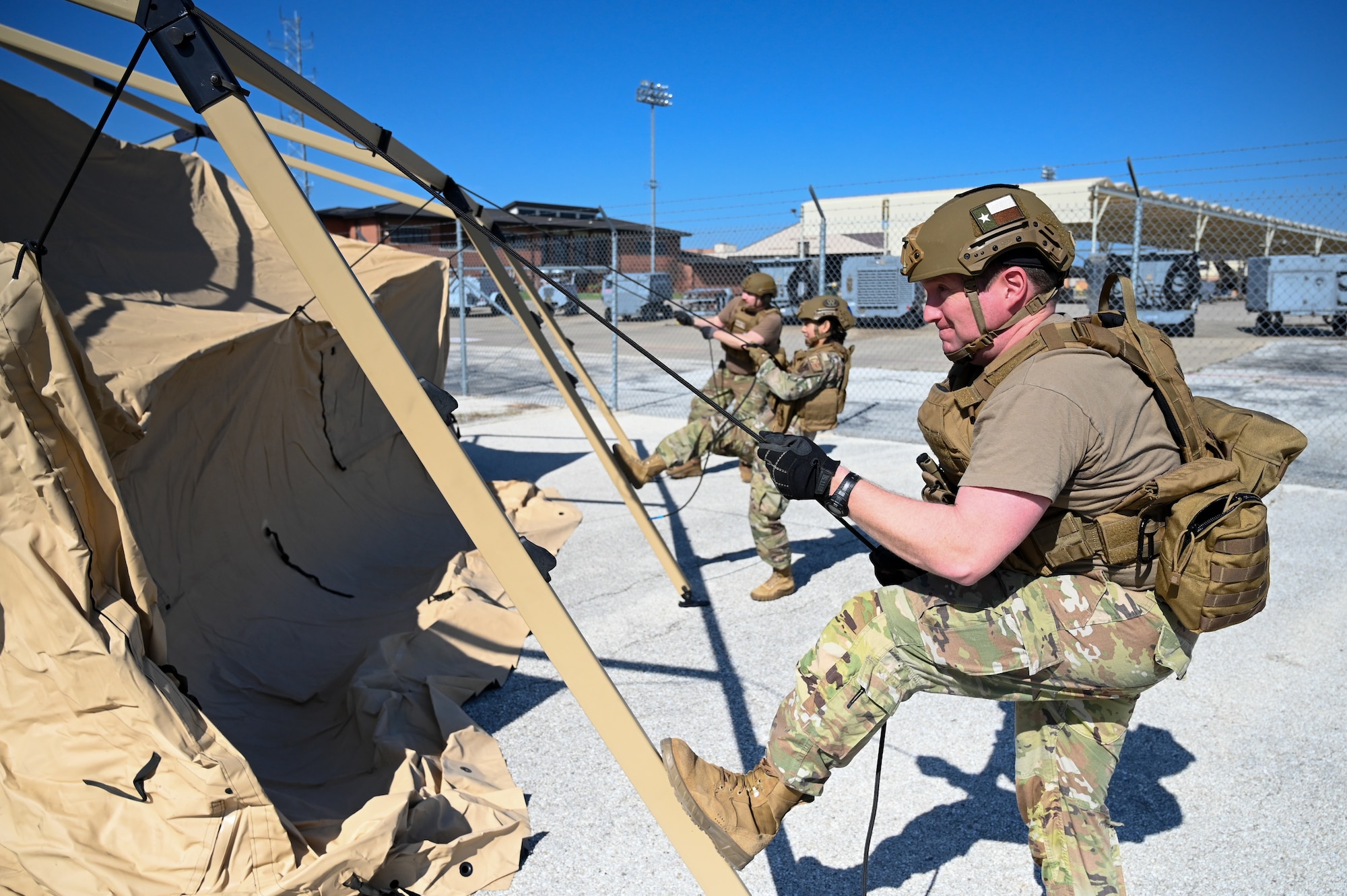 Maj. Alexander Williams, right, 433rd Contingency Response Flight commander, fastens tent ropes at a training campsite during a training event at Joint Base San Antonio-Lackland, Texas on Mar. 2, 2024.