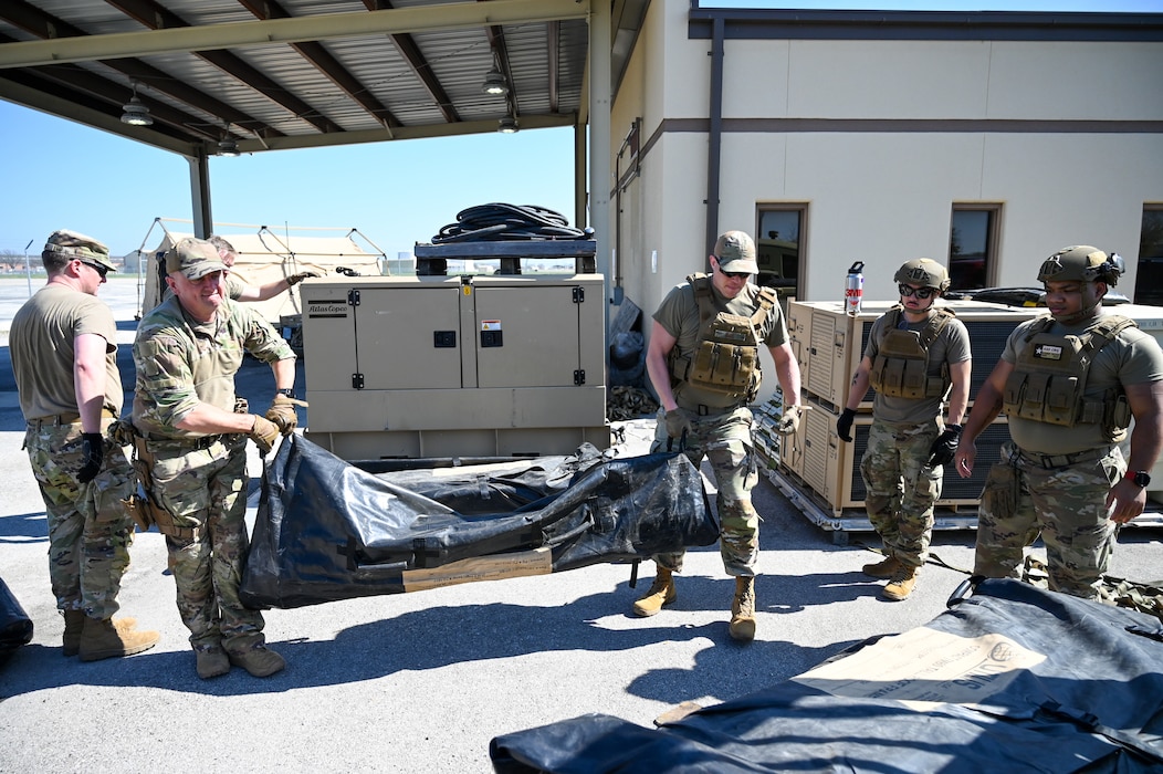 Senior Master Sgt. Bret Christofferson, center left, 433rd Contingency Response Flight senior enlisted leader, hauls equipment off a pallet to establish a training campsite during a training event at Joint Base San Antonio-Lackland, Texas on Mar. 2, 2024.