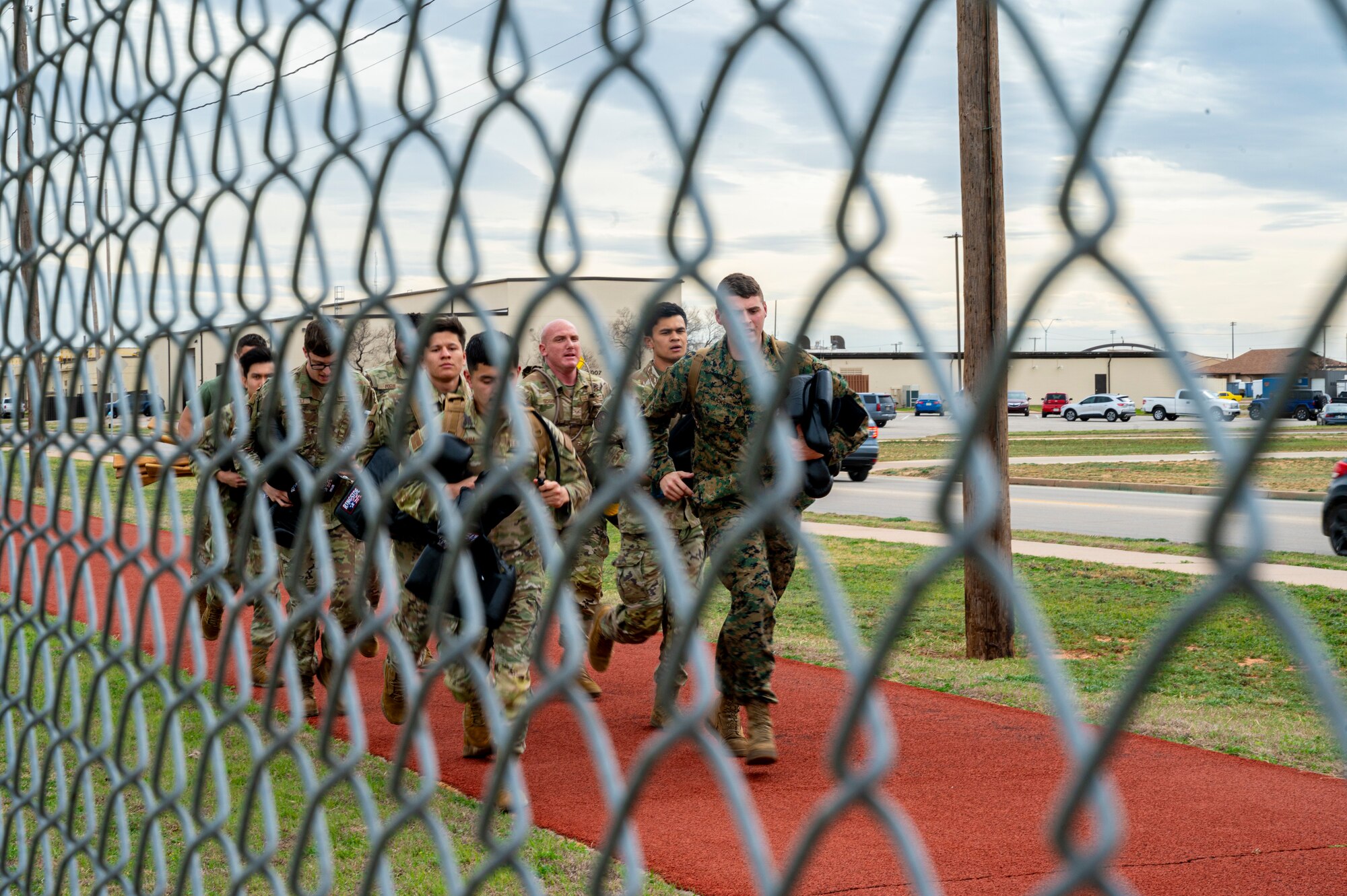 Dyess Airmen and Marines run during a Marine Corps Martial Arts Program course at Dyess Air Force Base, Texas, Feb. 27, 2024. The MCMAP is a mentally and physically rigorous two-week course where service members learn hand-to-hand and close quarters combative techniques to develop proficiency and skills in the warrior ethos. The program also improves mental and character development, including the correct use of force, leadership and teamwork. (U.S. Air Force photo by Airman 1st Class Alondra Cristobal Hernandez)