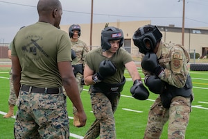 Dyess Airmen and Marines execute lower body strikes during a Marine Corps Martial Arts Program at Dyess Air Force Base, Texas, Feb. 27, 2024. During MCMAP Airmen were taught self-defense and close-quarter combat skills by Dyess Marines. This program was originally developed specifically for Maines and Sailors attached to Marine units but has become available to service members in other branches throughout recent years. (U.S. Air Force photo by Airman 1st Class Alondra Cristobal Hernandez)