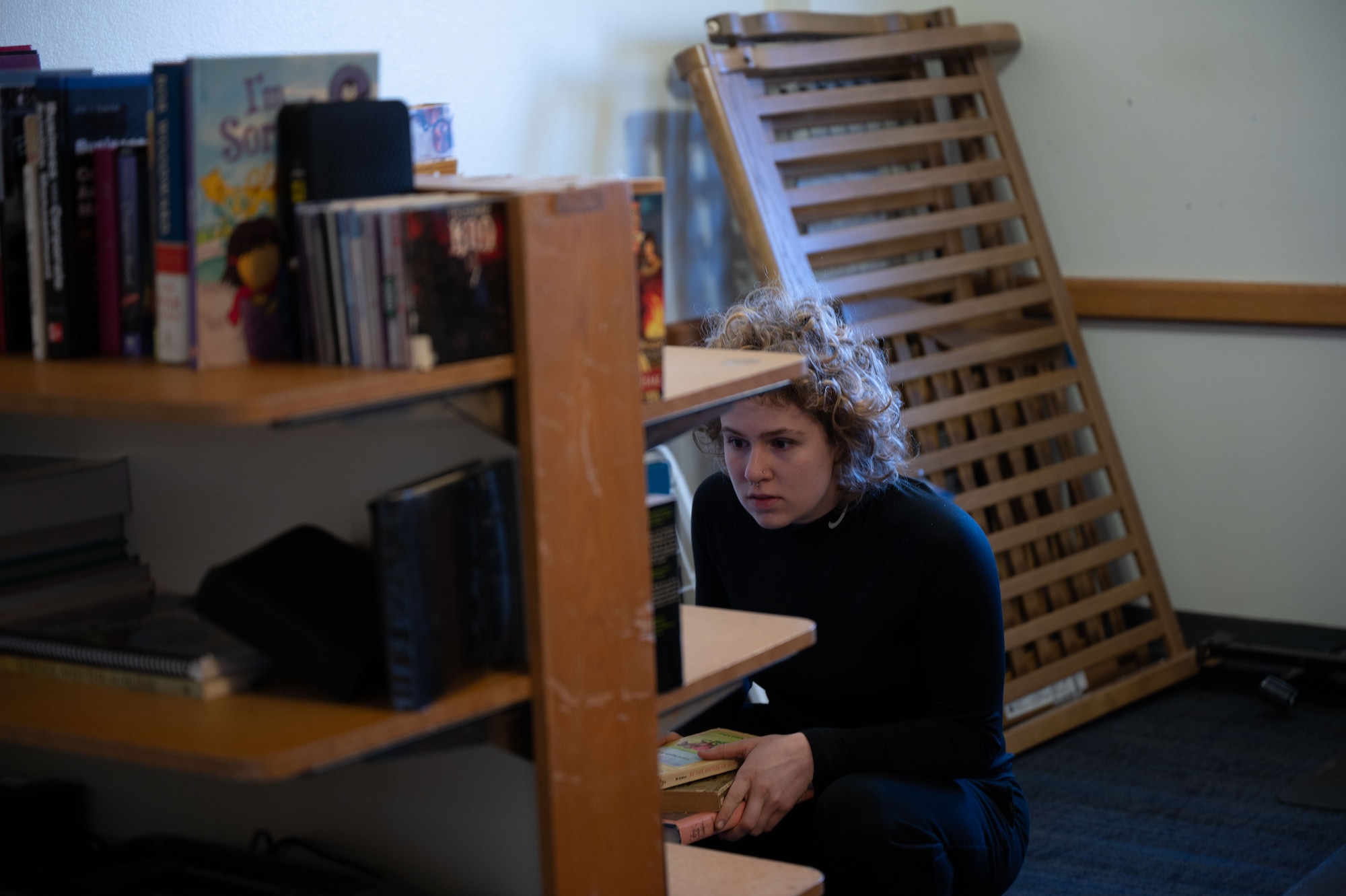 Women crouching at a bookshelf
