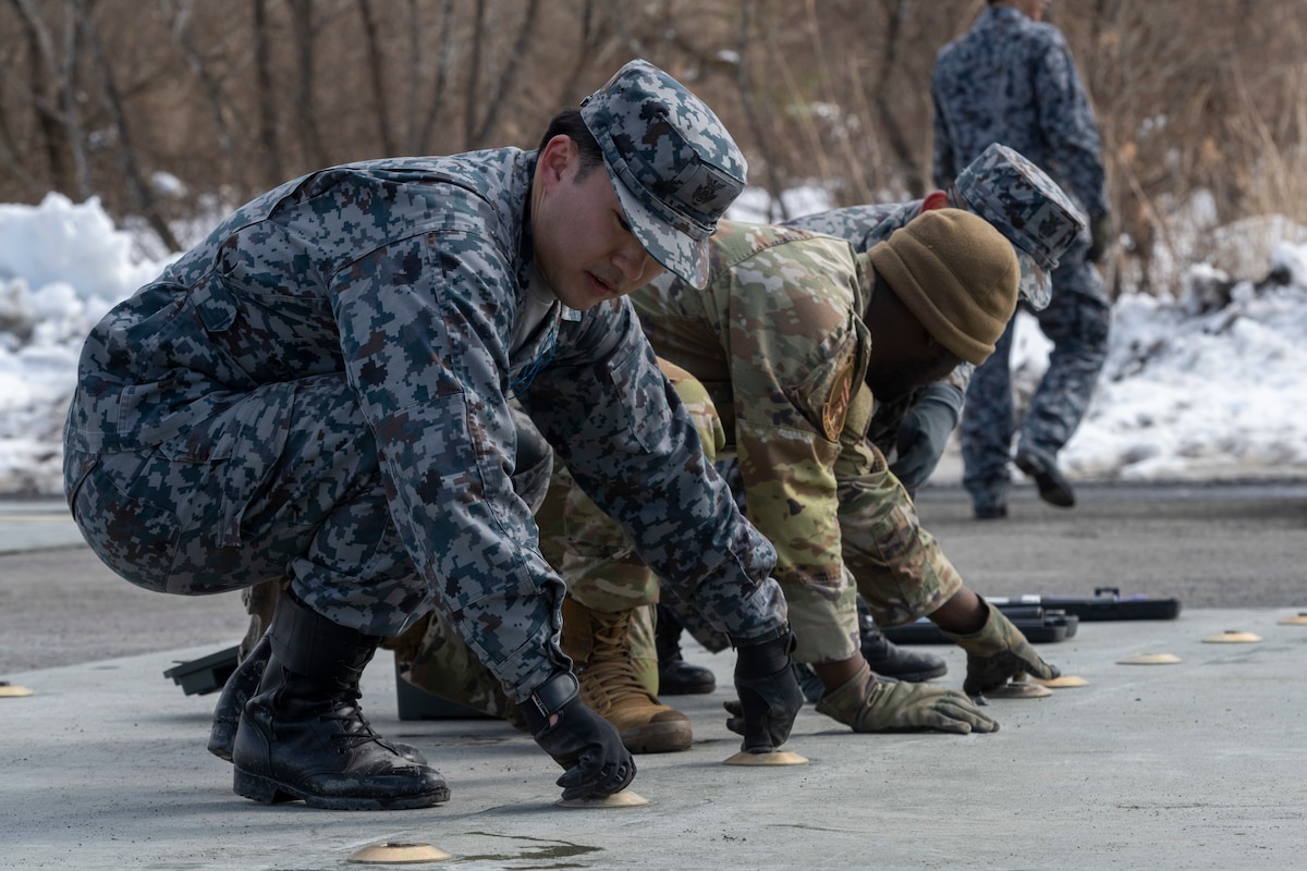 Japan Air Self-Defense Force (JASDF) and U.S. Air Force Airmen work together  on a flight line repair exercise during a Multi-Capable Airman course at Misawa Air Base, Japan, March 8, 2024.