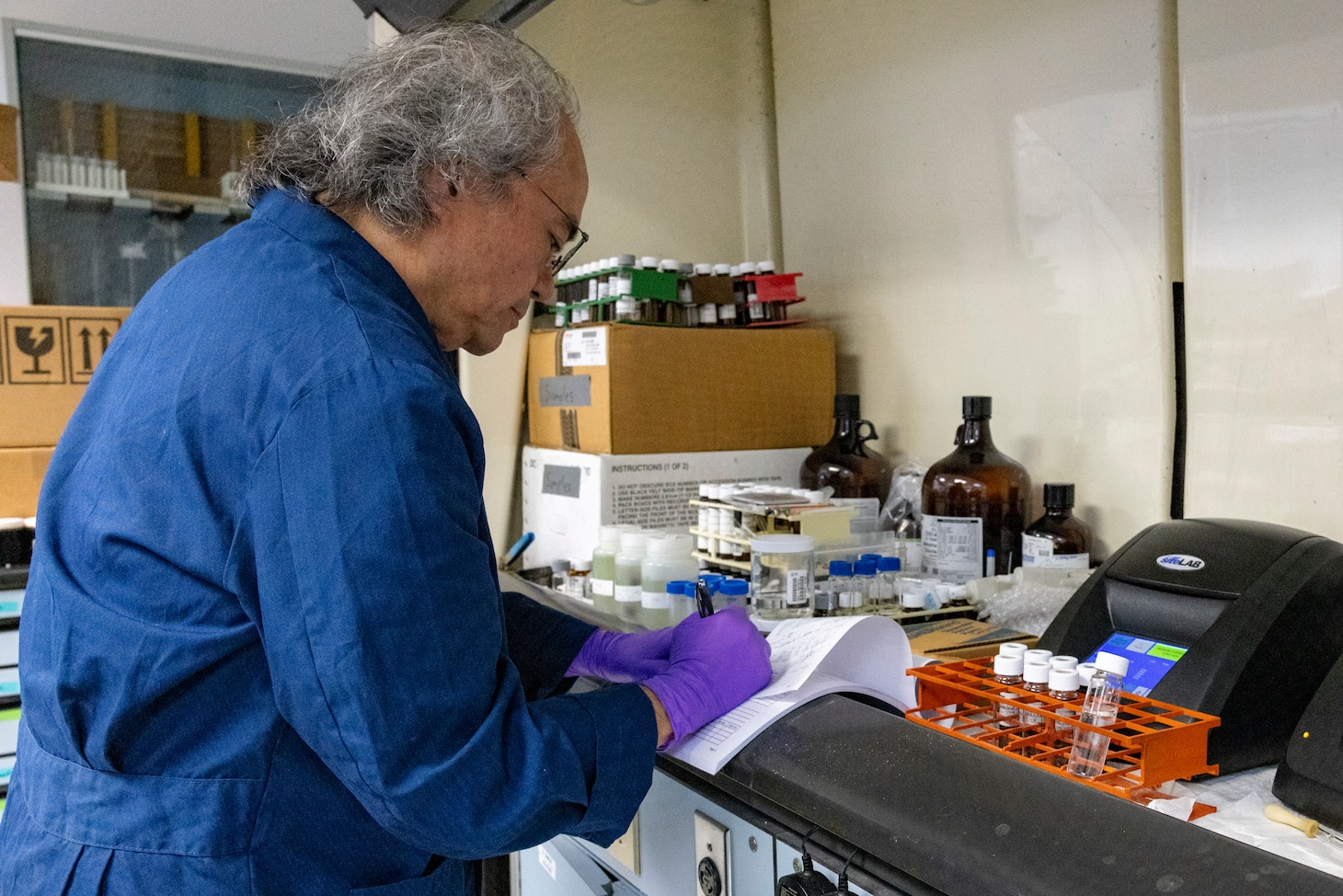 Duane Morita, laboratory director, Naval Facilities Engineering Systems Command Hawaii, takes notes during water sample testing at Environmental Services Laboratory, Joint Base Pearl Harbor-Hickam, Hawaii, March 5. The ongoing monitoring efforts are part of the Navy’s enduring, long-term commitment to ensure the safety of the environment and public health. (U.S. Navy photo by Mass Communication Specialist Seaman Krystal Diaz)