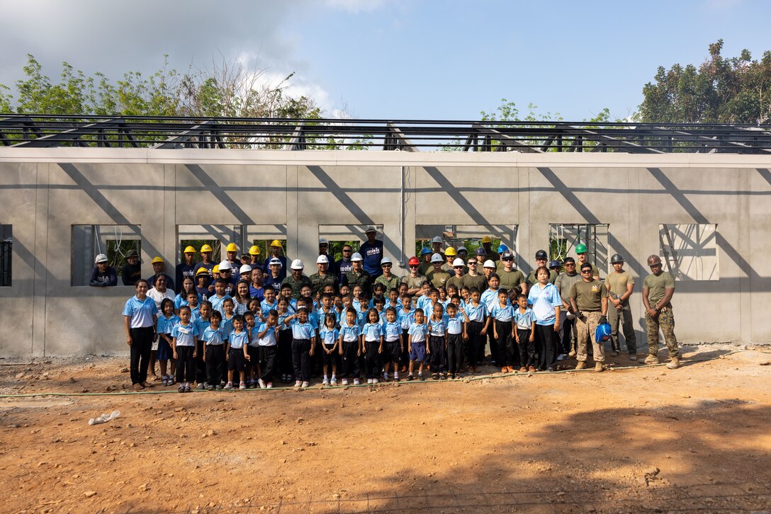 Students of the Ban Prakaet school take a group photo with Marines from Marine Wing Support Squadron (MWSS) 171, Marine Aircraft Group 12, Royal Thai marines with the Royal Thai Marine Corps Construction and members of the 30th Battalion, Singapore Combat Engineers in front of the newly constructed building at their school in Chanthaburi, Thailand, Feb. 23, 2024. Marines of MWSS-171 lent their engineering expertise to multilateral humanitarian efforts during Cobra Gold 24. Joint Exercise Cobra Gold is the largest joint exercise in mainland Asia and a concrete example of the strong alliance and strategic relationship between Thailand and the United States. This year is the 43rd iteration of the multilateral exercise, held from Feb. 27 to March 8, 2024. (U.S. Marine Corps photo by Cpl. Calah Thompson)