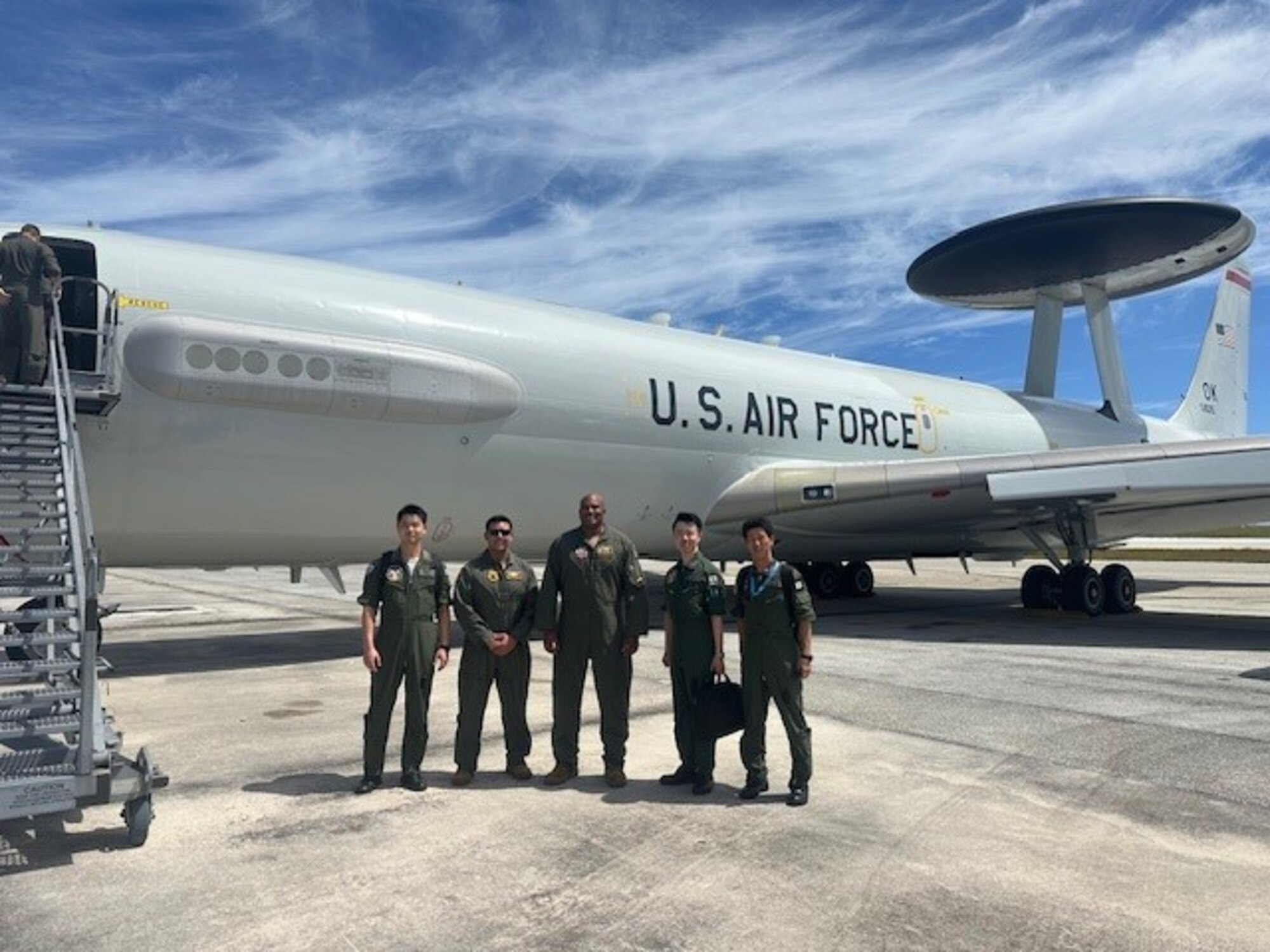 Men standing in front of E-3 AWACS aircraft